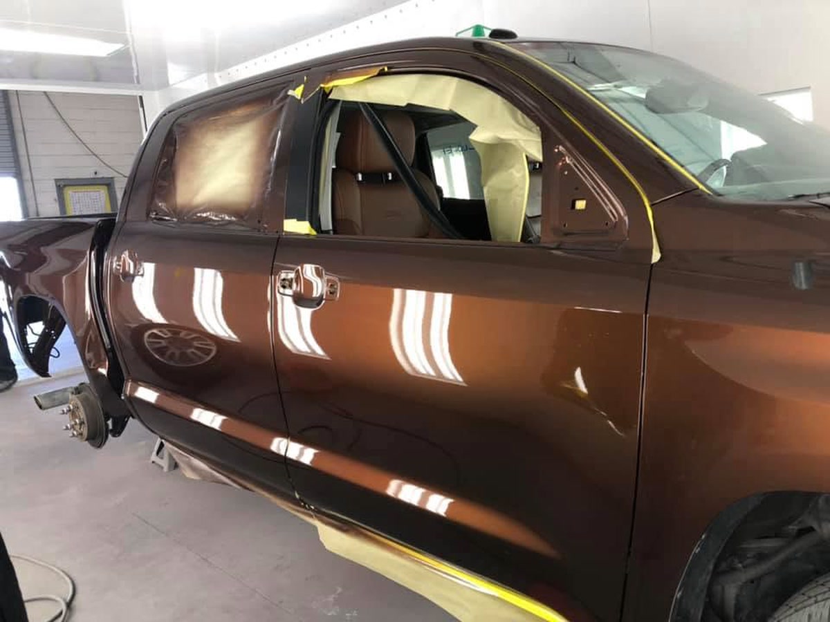 A pickup masked for refinishing in the paint booth at Superior Collision, serving Brownsville and the Rio Grande Valley