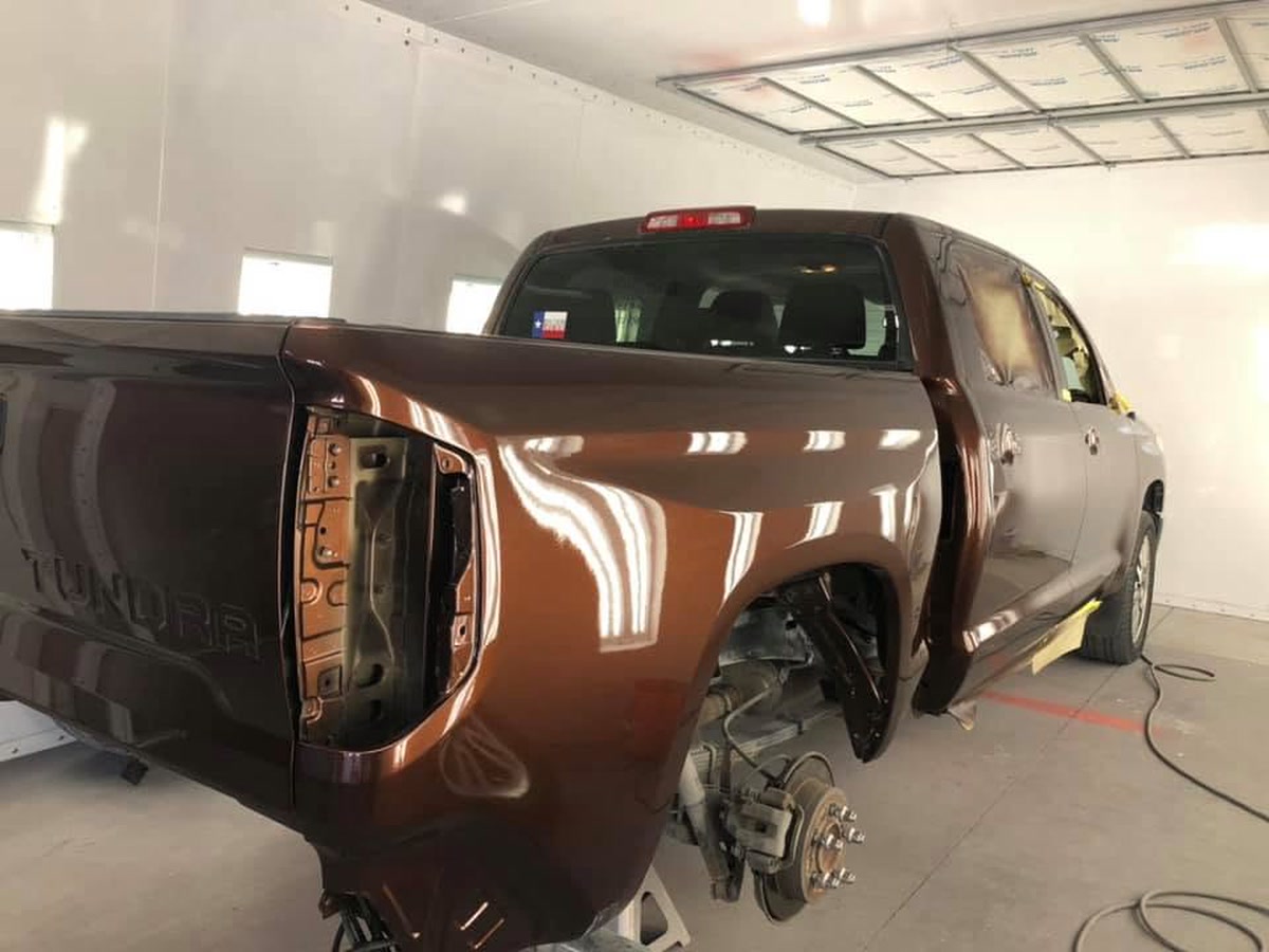 A pickup with its rear quarter panel removed to reach the damage underneath, at Superior Collision in Brownsville, TX